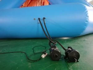 Inflating water slide module on shore during installation process