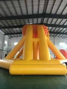 Guide team adjusting inflatable water slide module on lake surface