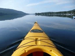 Single rider water tube gliding across lake surface behind boat