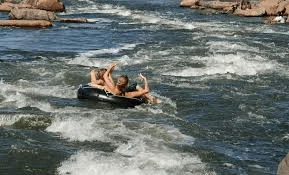 Tubing boat driver controlling speed and watch observer