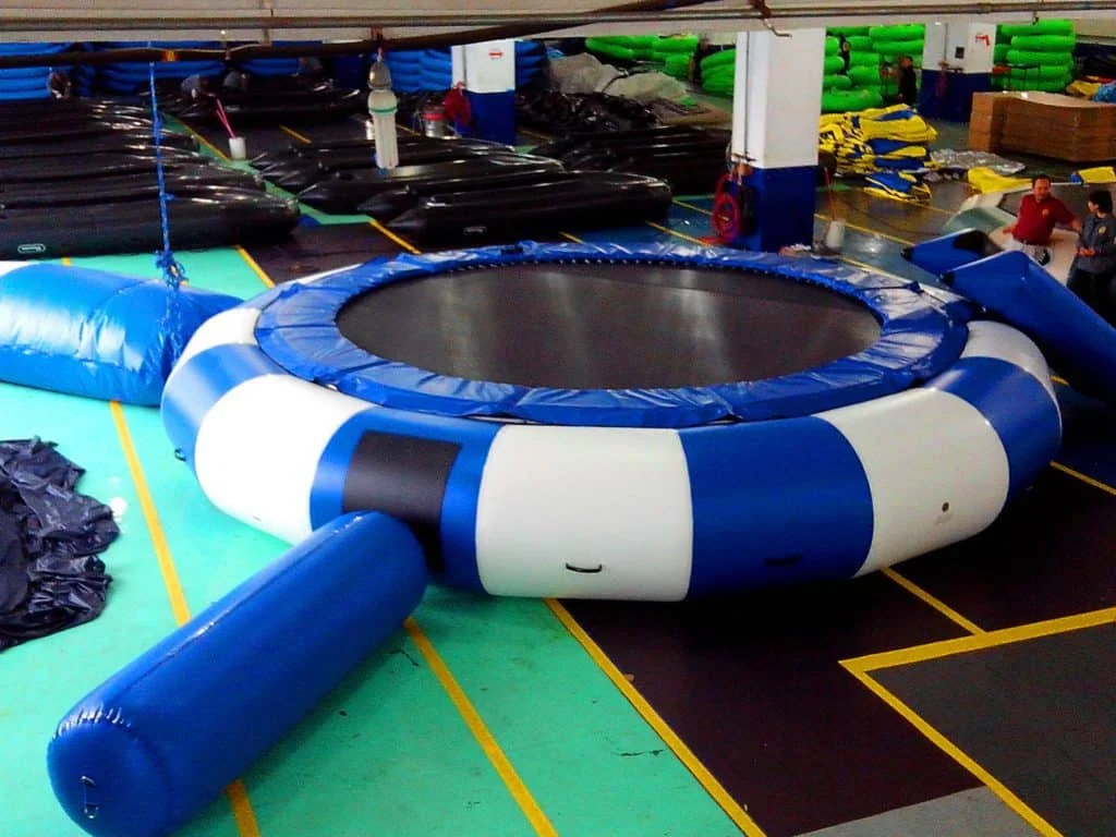 Classic circular inflatable water trampoline anchored on a calm lake