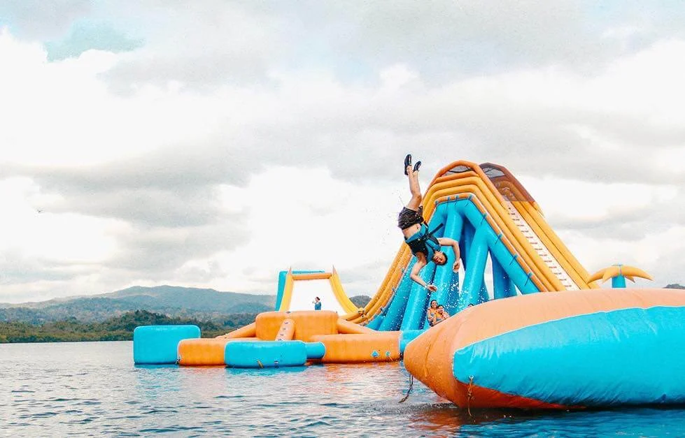 Floating inflatable obstacle course with climbing wall and slide