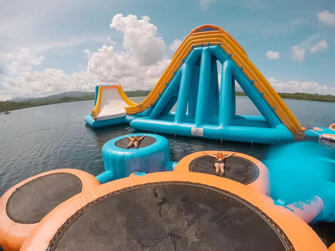Inflatable water trampoline with attached climbing slide module