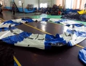 Unfolding inflatable water trampoline on shore for inflation setup