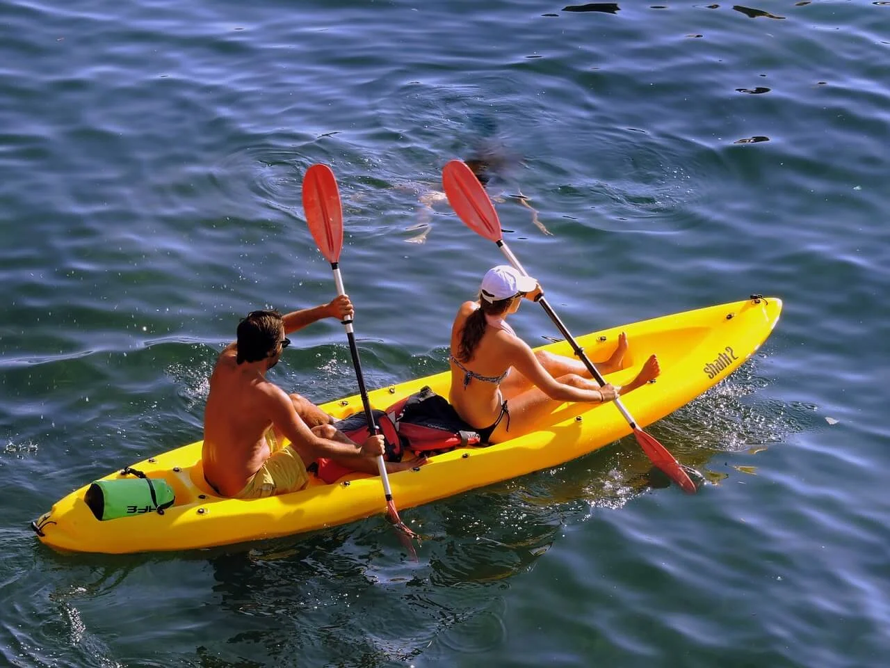Beginner kayaker paddling on calm lake water