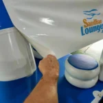 A person putting a white plastic wrap on a blue and white table
